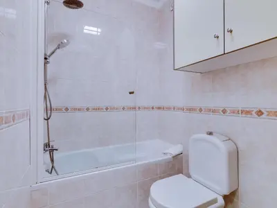 a bathroom with a shower and a toilet and a tub at Apartamento Mourasuites, T1 moderno em Vilamoura in Quarteira