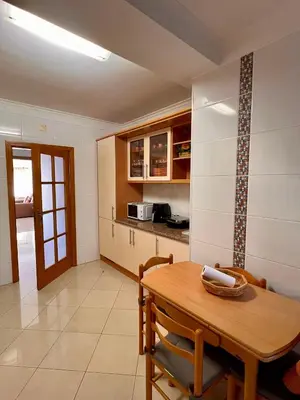 a kitchen and dining room with a wooden table at Vilamoura apartment in Quarteira