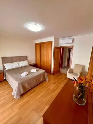 a hotel room with a bed and a chair at Vilamoura apartment in Quarteira