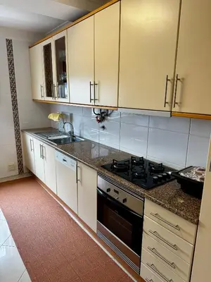 a kitchen with white cabinets and a stove top oven at Vilamoura apartment in Quarteira