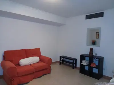 a living room with a red couch and a table at EncostaOasis Townhouse in Estibeira
