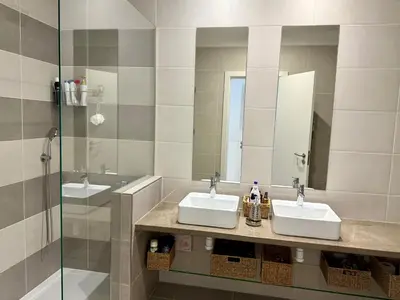 a bathroom with two sinks and a glass shower at Gabbiana apartment Albufeira terrace BBQ and pool in Albufeira