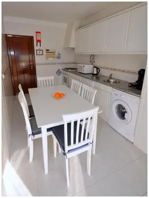 two oranges in a bowl on a white table in a kitchen at Apartamentos Capitolina in Quarteira