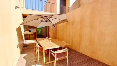 a wooden table and chairs with an umbrella on a deck at Casa Centavo - Natura Village, CD 317 - Cleverdetails in Quarteira