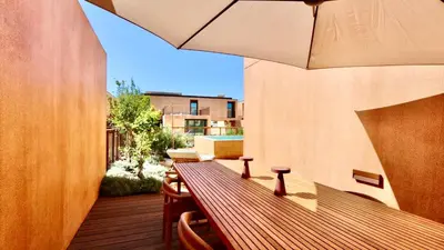 a balcony with a wooden table and an umbrella at Casa Centavo - Natura Village, CD 317 - Cleverdetails in Quarteira