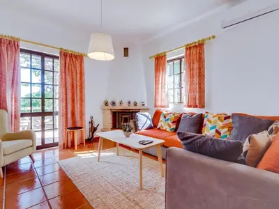 a living room with a couch and a table at Vivenda Pereiras com 2 quartos em Quarteira in Quarteira