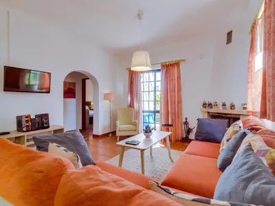 a living room with a couch and a table at Vivenda Pereiras com 2 quartos em Quarteira in Quarteira