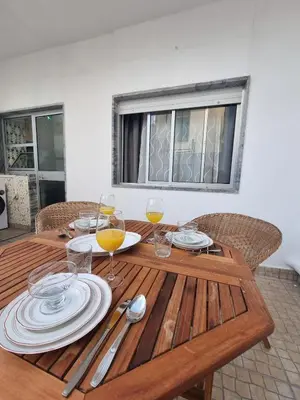 a wooden table with plates and wine glasses on it at Happy House - Central Apartment in Faro