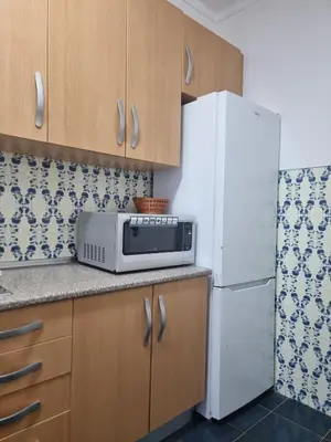 a kitchen with a microwave and a refrigerator at Happy House - Central Apartment in Faro