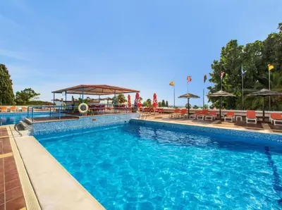 a pool at a hotel with chairs and umbrellas at Sea view studio, terrace & pools - Albufeira in Albufeira