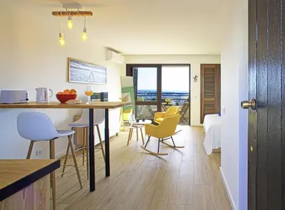 a kitchen and living room with a table and chairs at Sea view studio, terrace & pools - Albufeira in Albufeira