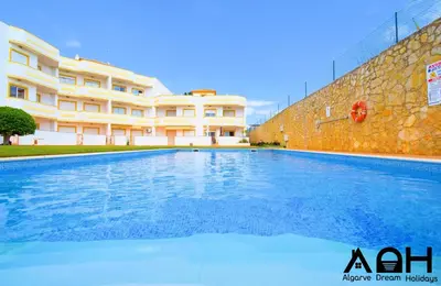 a large swimming pool in front of a building at Sunny Terrace facing the pool and barbecue by Algarve Dream Holidays in Guia