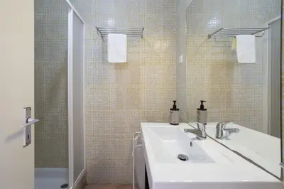 a bedroom with a bed and a ladder and towels at Cozy 2BR Apartment in Albufeira with Balcony, by Hopstays in Albufeira