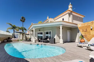 a villa with a swimming pool in front of a house at Quiet Villa Near The Beach, Opcional Heated Pool in Albufeira