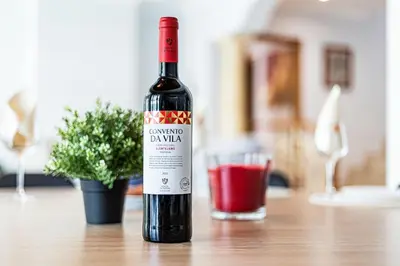 a bottle of wine sitting on a table next to a glass at Quiet Villa Near The Beach, Opcional Heated Pool in Albufeira