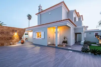 a white house with a wooden deck at Quiet Villa Near The Beach, Opcional Heated Pool in Albufeira