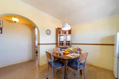 a dining room with a wooden table and chairs at Vivenda Lemos A in Albufeira