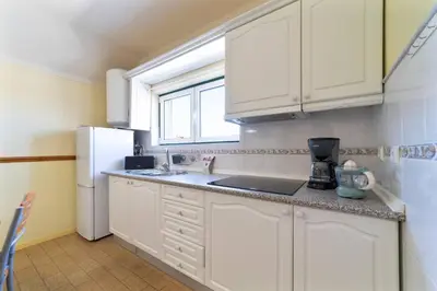 a kitchen with white cabinets and a white refrigerator at Vivenda Lemos A in Albufeira