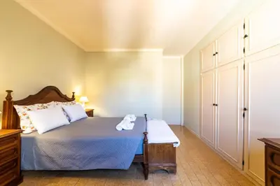 a bedroom with a bed with a wooden headboard at Vivenda Lemos A in Albufeira