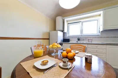 a kitchen with a wooden table with oranges on it at Vivenda Lemos A in Albufeira