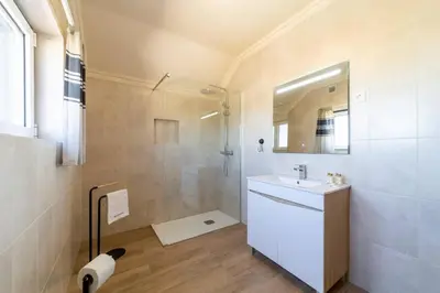 a bathroom with a white sink and a shower at Vivenda Lemos A in Albufeira