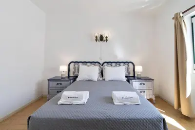 a bedroom with a blue bed with two night stands at Vivenda Lemos B in Albufeira