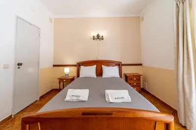 a bedroom with a bed with two towels on it at Vivenda Lemos C in Albufeira