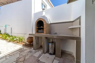 a outdoor kitchen with a brick oven on a patio at Vivenda Lemos C in Albufeira