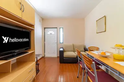 a kitchen and living room with a table and a television at Vivenda Lemos D in Albufeira