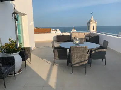 a patio with a table and chairs and the ocean at Bay View Apartments in Albufeira