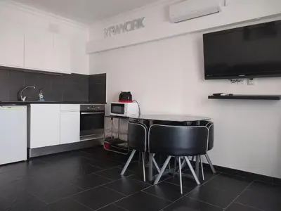 a kitchen with a table and chairs and a tv at Bay View Apartments in Albufeira