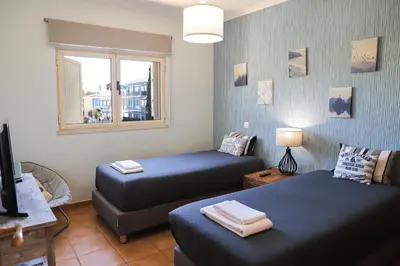 a room with two beds and a window at Atlântida Golf Village by Garvetur in Quarteira