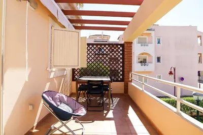 a balcony with a table and chairs on it at Atlântida Golf Village by Garvetur in Quarteira