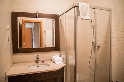 a bathroom with a sink and a shower with a mirror at Terraços do Milénio II by Garvetur in Quarteira