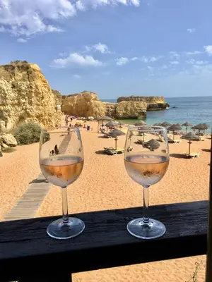 two glasses of wine sitting on a table near the beach at Apartamento Vida & Mar at Albufeira Beach in Albufeira