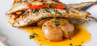 a plate of food with fish and potatoes at Apartamento Vida & Mar at Albufeira Beach in Albufeira