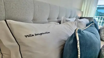 a pillow with the words wildlife bombardment on it sitting on a bed at Casa Bougainvillea by CleverDetails, private pool 