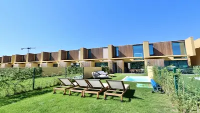 a group of chairs sitting in the grass in front of a building at Casa Bougainvillea by CleverDetails, private pool 
