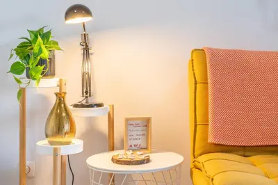 a living room with a yellow chair and a lamp at Falésia Beach I by HelloVacations in Albufeira