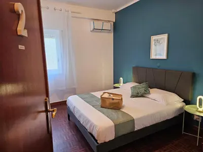 a hotel room with a bed with a bag on it at Blife Olindya private rooms in Faro