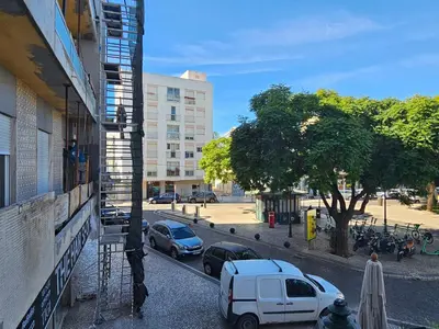 a view of a street with cars parked next to a building at Blife Olindya private rooms in Faro