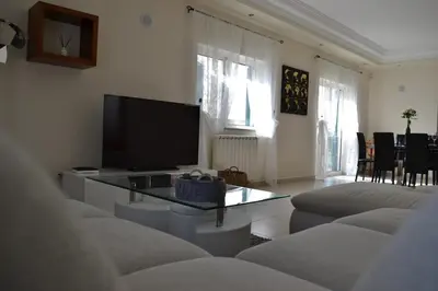 a living room with a flat screen tv and couches at Magnifique Villa à 10min de la mer in Faro