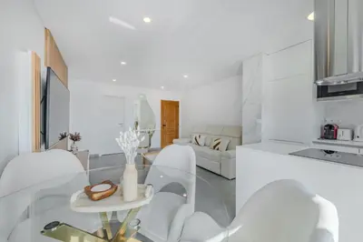 a white living room with white chairs and a table at Alexandra Paradise in Albufeira