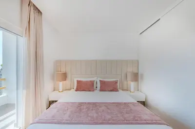 a bedroom with a large white bed with red pillows at Alexandra Paradise in Albufeira