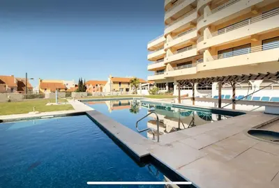 a swimming pool in front of a building at Algarve Vilamoura Quarteira vue sur Ocean-Portugal in Quarteira