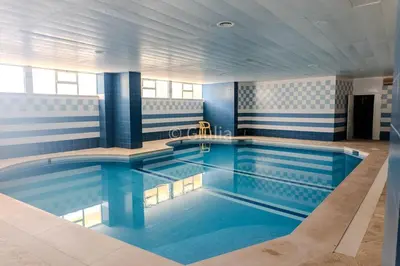 a large pool with blue water in a building at Algarve Vilamoura Quarteira vue sur Ocean-Portugal in Quarteira