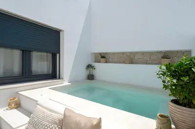 a swimming pool in a house with a window at Townhouse with Heated Pool in Downtown Faro in Faro