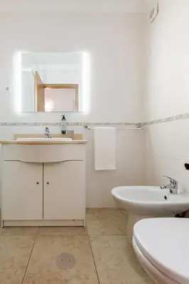 a white bathroom with a sink and a toilet at Albufeira Coast Apartment by Double Ninety Stays in Albufeira