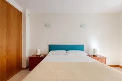a bedroom with a large bed with a blue headboard at Albufeira Coast Apartment by Double Ninety Stays in Albufeira
