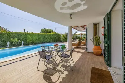 a patio with a table and chairs next to a pool at Villa Medicis by Villa Plus in Albufeira